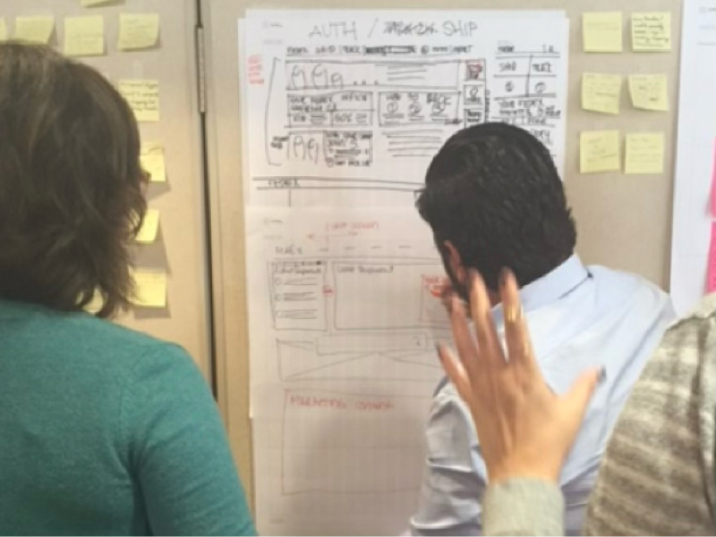Team members collaborating on a FedEx landing-page sketch during a design workshop