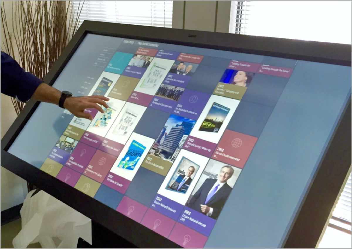 Person exploring the colorful historical timeline on a large touchscreen display